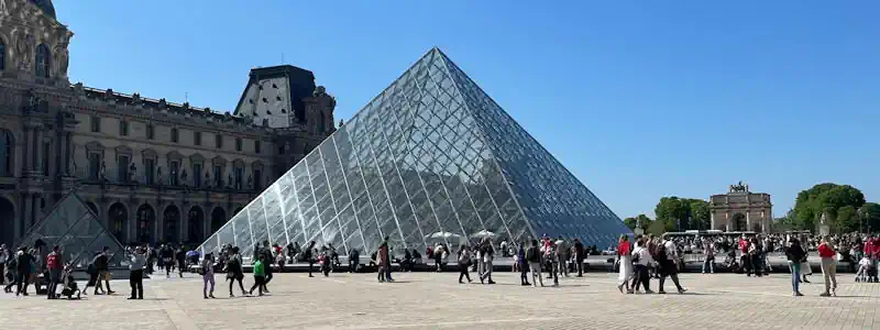 Personensuche in Frankreich hier symbolisiert mit Menschen vor der Glaspyramide im Innenhof des Louvre in Paris.